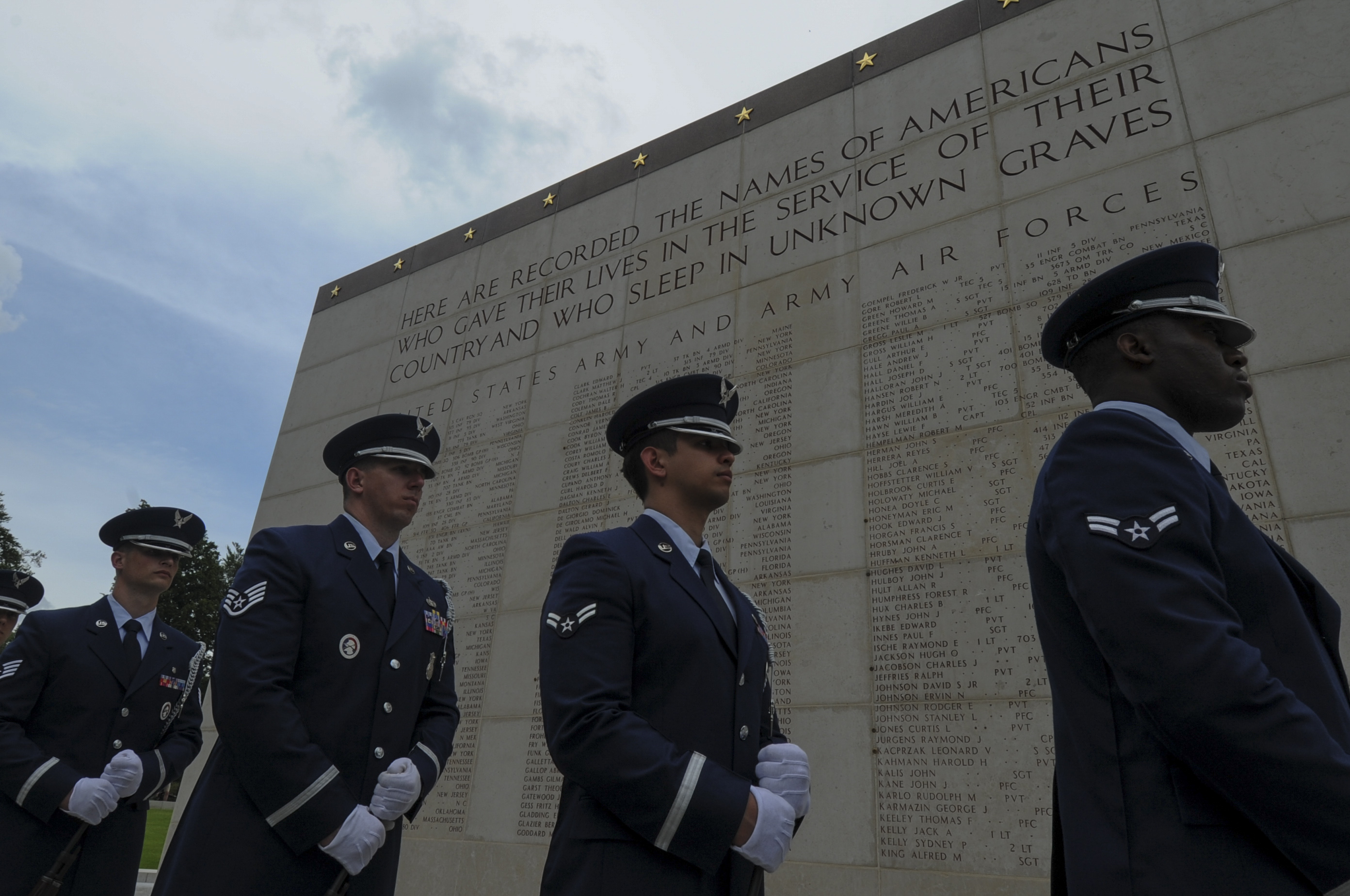 Members of the Air Force stand in front of the Wall of the Missing. 