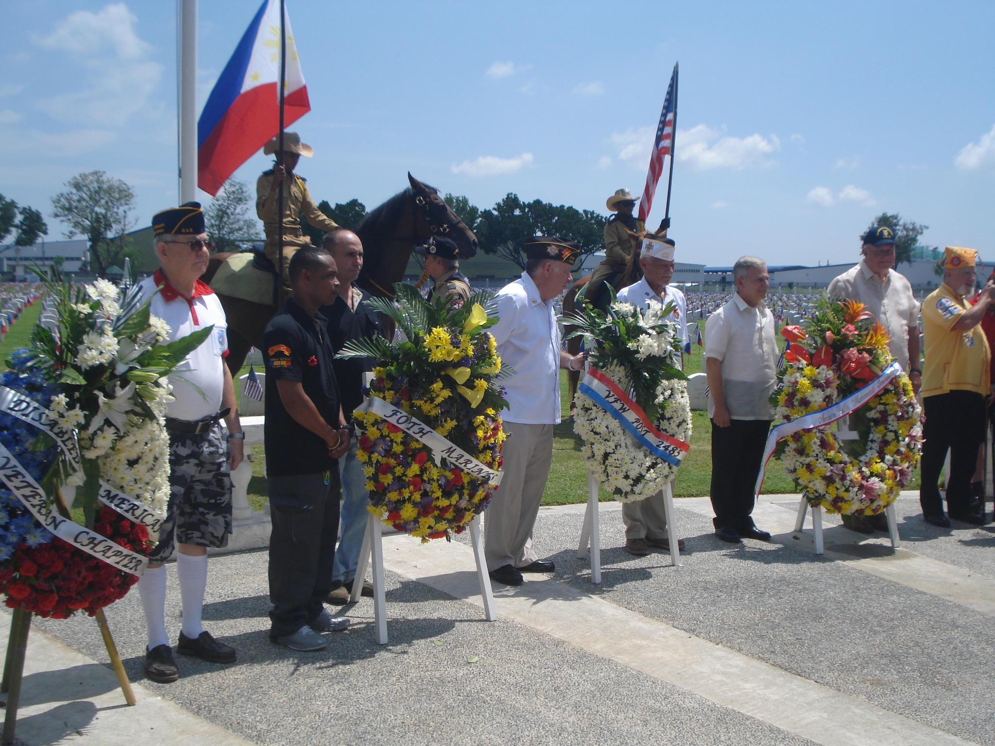 Wreath layers stand next to the floral wreaths during the ceremony. 