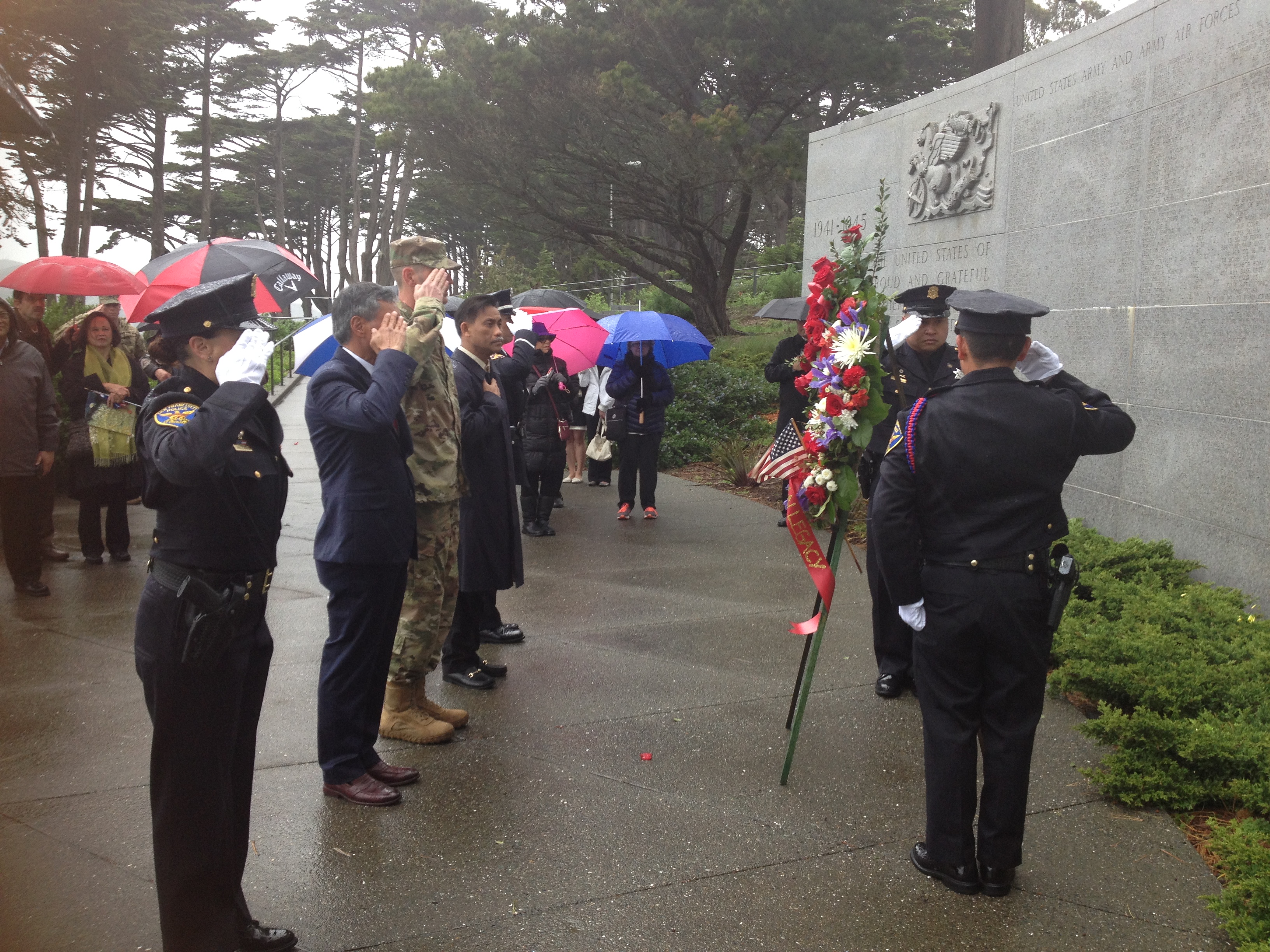 People salute after laying a wreath at the memorial. 