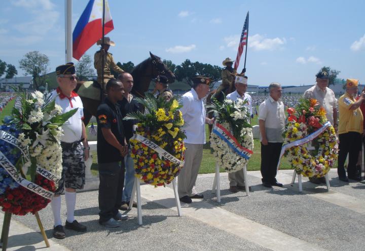 Wreath layers stand next to the floral wreaths during the ceremony. 