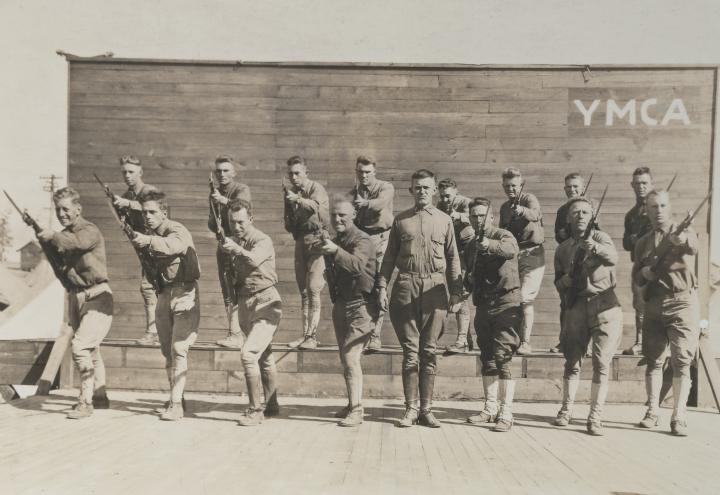 Historic photo showing soldiers thrusting bayonets forward. 