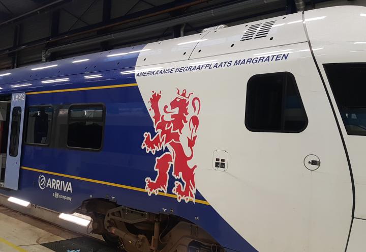 The outside of the train car includes the name Amerikaanse Begraafplaats Margraten.