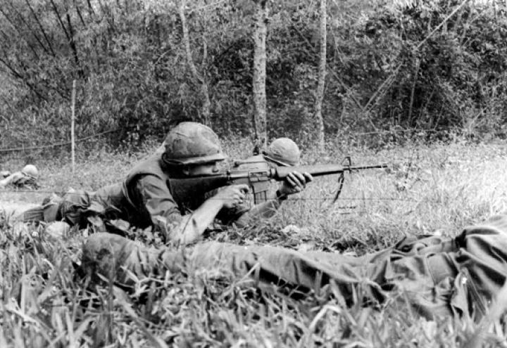 Historic photo shows a man firing a weapon. 