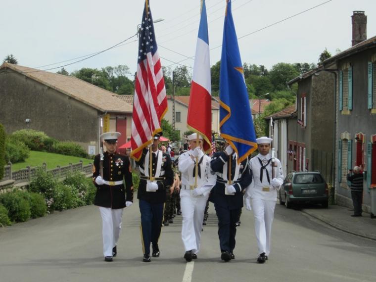 A color guard marches with flags down a street. 