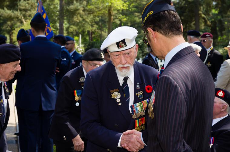 Two attendees shake hands at the Memorial Day 2012 ceremony at Brookwood American Cemetery.