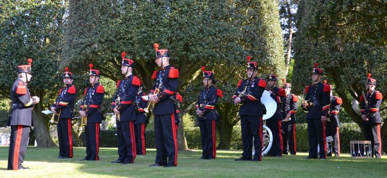 A French military band stands with instruments, ready to play during the ceremony. 