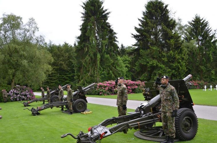 Luxembourg military troops stand next to cannons. 