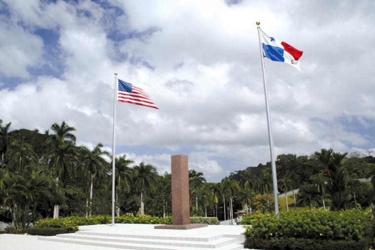 Flags and obelisk at the memorial plaza at Corozal American Cemetery.