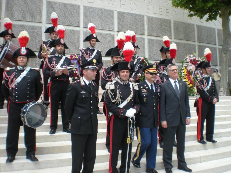 Members of the Italian military stand on steps in front of the Wall of the Missing. 
