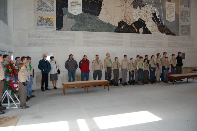 Boy Scouts stand in the chapel, waiting for the ceremony to begin. 