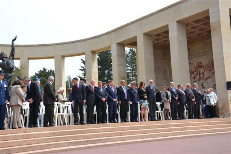 Officials stand next to chairs at the top of the memorial area.