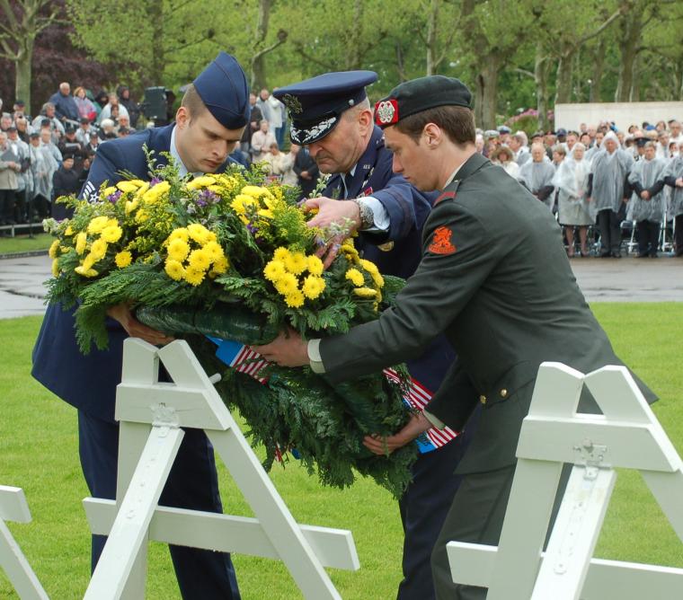 Men in uniform lay a floral wreath during the ceremony. 