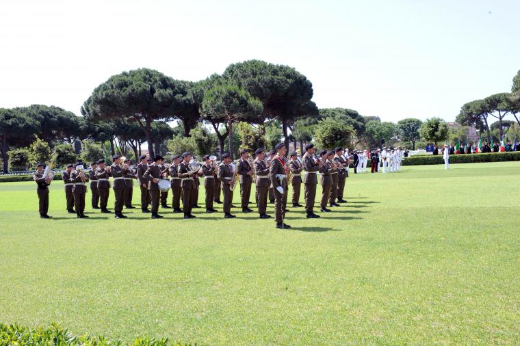 Italian military band members stand with instruments. 