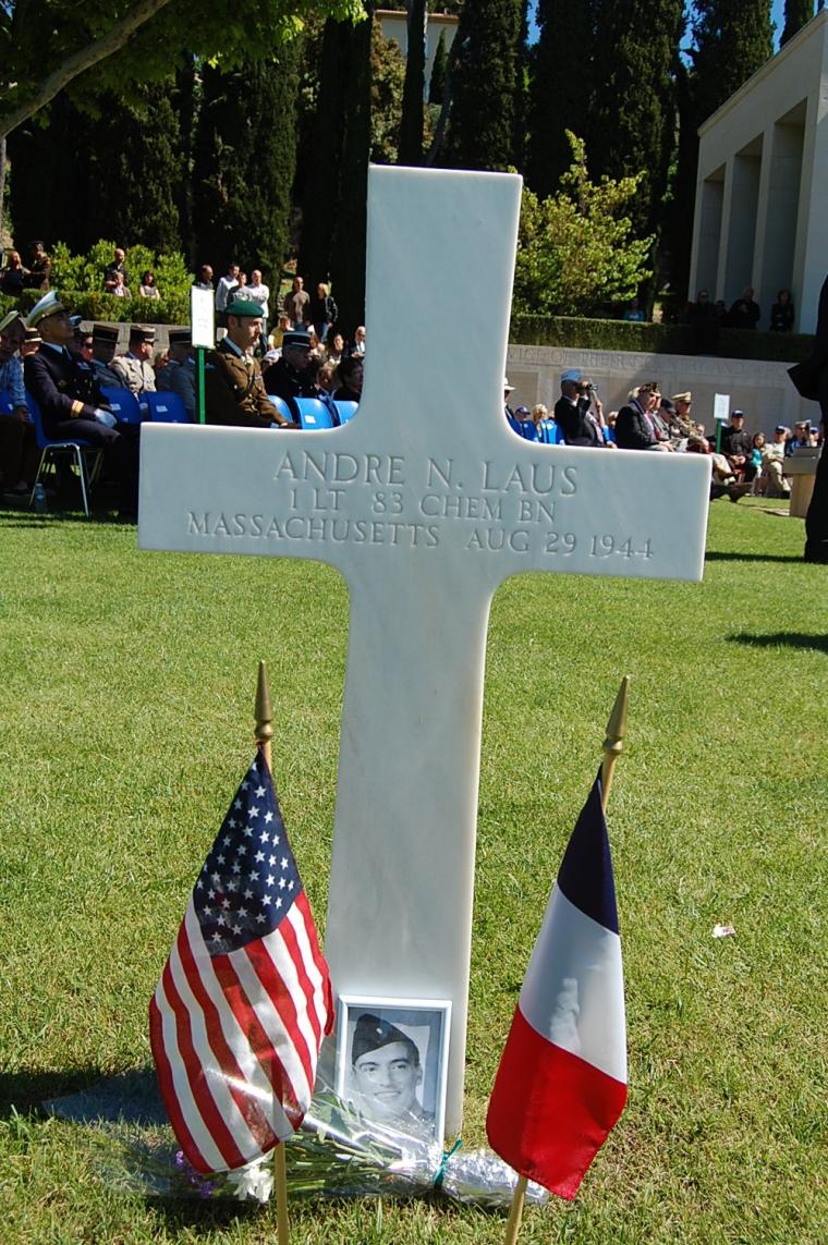 A photo, flowers, and a French and American flag are at the headstone of 1st Lt. Andre N. Laus. 