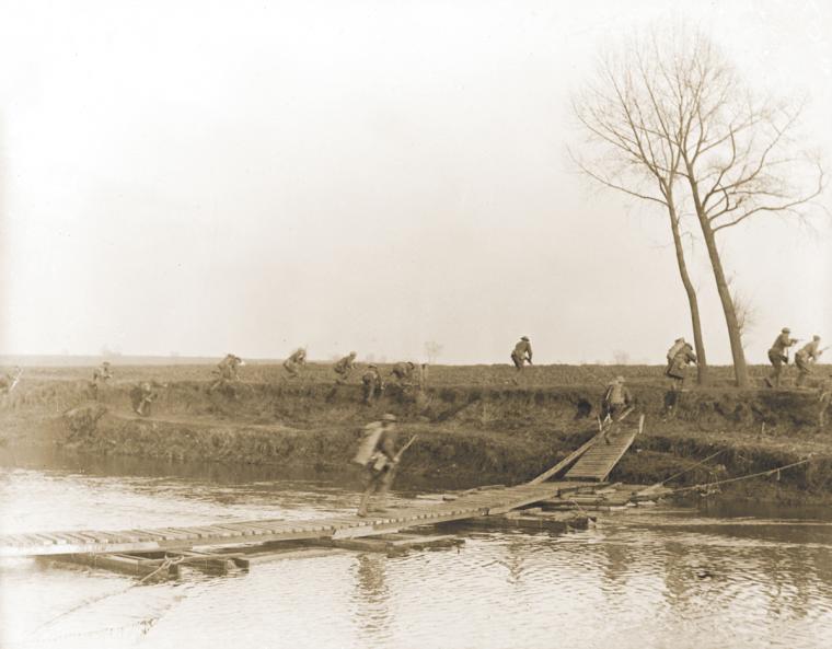 Soldiers of the 146th Infantry, 37th Division, crossing the Scheldt River at Nederzwalm under fire.
