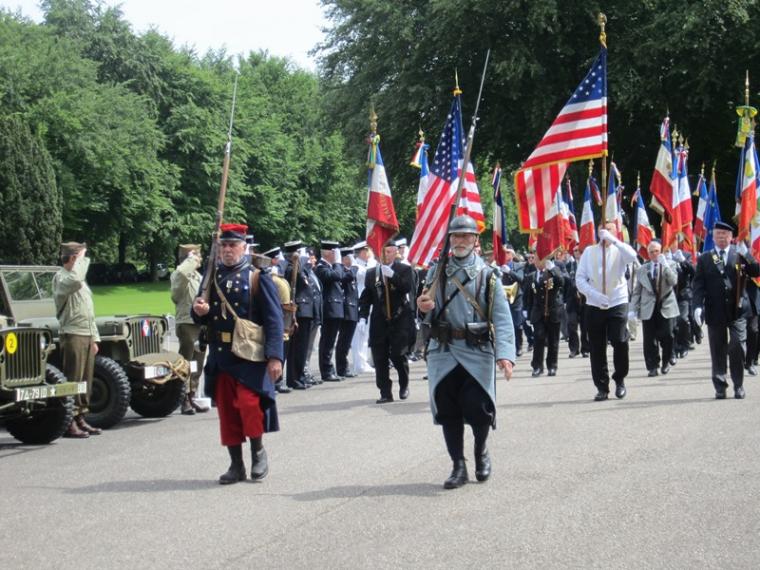 Men in uniforms march with flags.