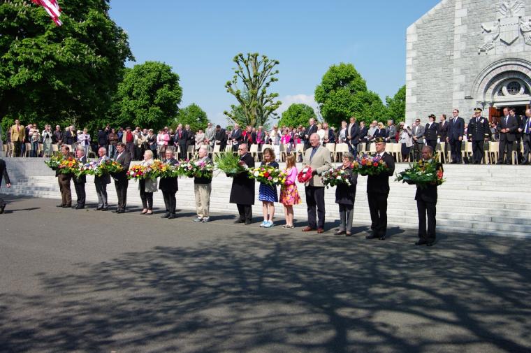 Participants stand with floral wreaths in hand.