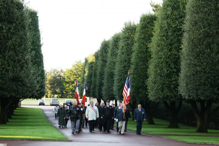 Participants walk down a main path at Normandy American Cemetery for the start of the 2012 Veterans Day ceremony.