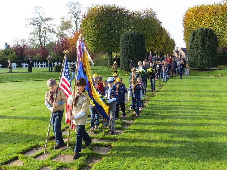 Boy Scouts carrying flags march in at Flanders Field American Cemetery for the 2012 Veterans Day ceremony. 