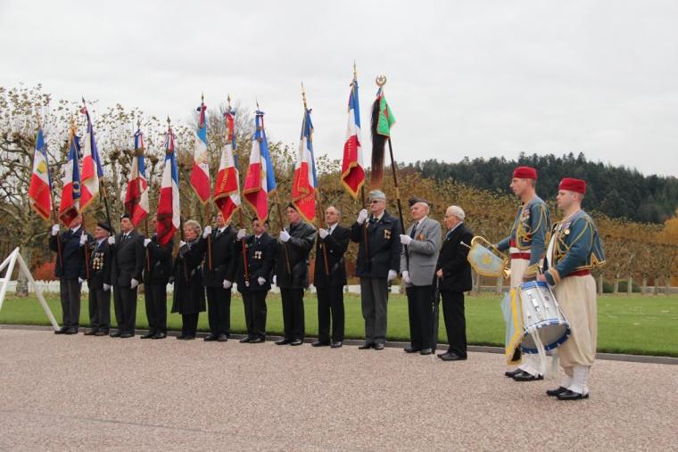 A line of men with flags stand during the 2012 Veterans Day ceremony at Epinal American Cemetery. 