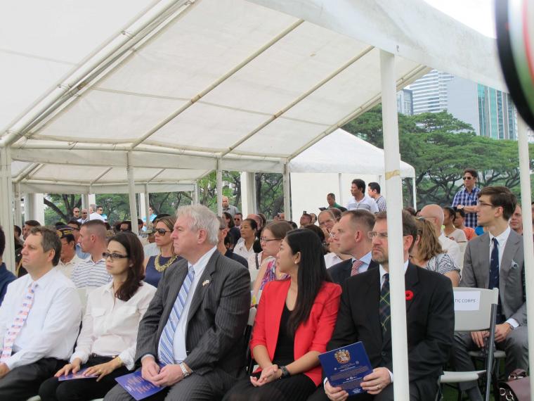 Attendees sit in rows under a tent during the ceremony. 