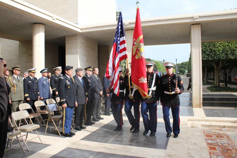 Members of the military arrive bearing flags during the 2012 Veterans Day ceremony at North Africa American Cemetery. 