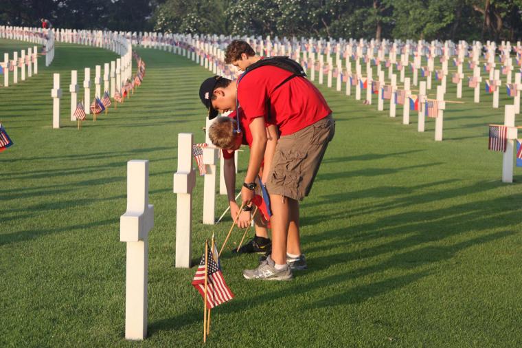 Flags are placed in front of headstones at Manila American Cemetery for Memorial Day.