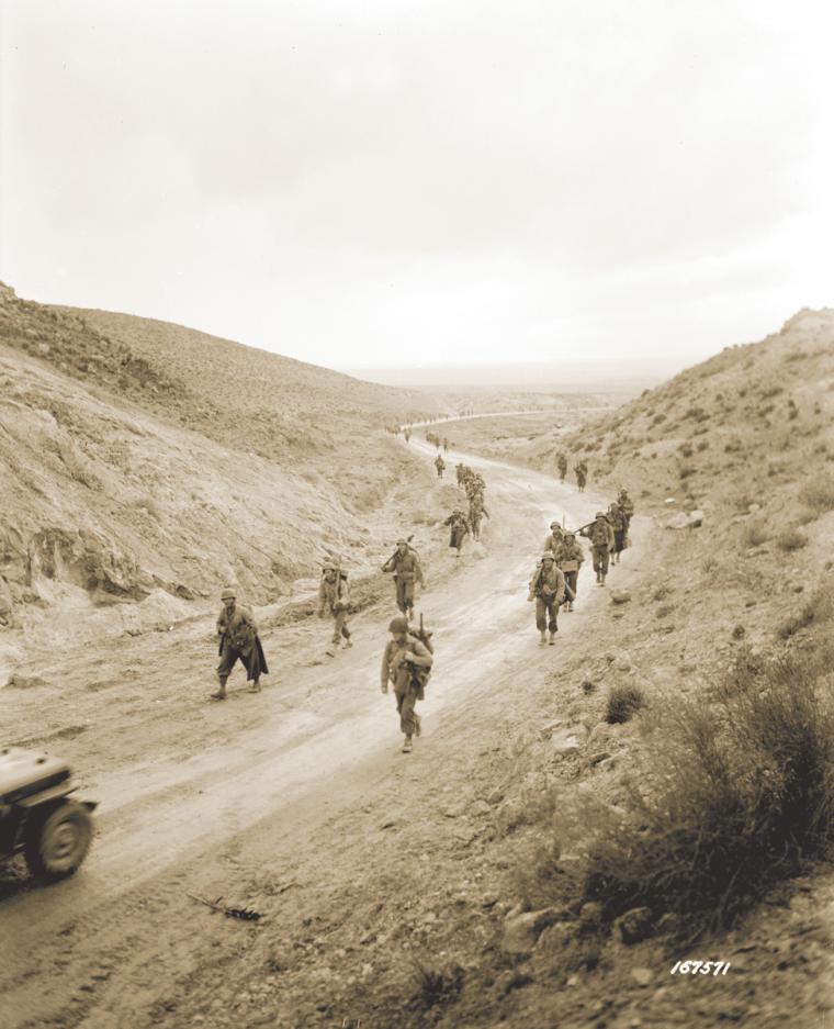 1st Infantry Division soldiers advance through Kasserine Pass, Feb. 26, 1943.
