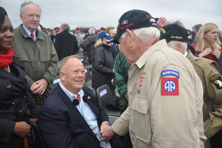 ABMC Secretary Max Cleland shakes hands with a D-Day veteran.