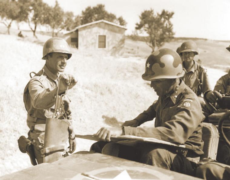 Soldiers converse while sitting in a jeep.