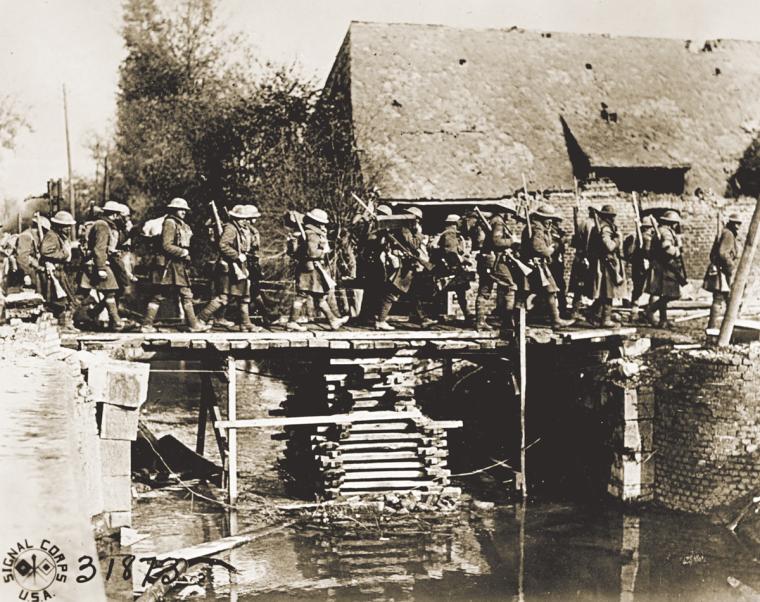 Soldiers of the 27th Division cross a temporary bridge at St. Souplet, October 19, 1918.