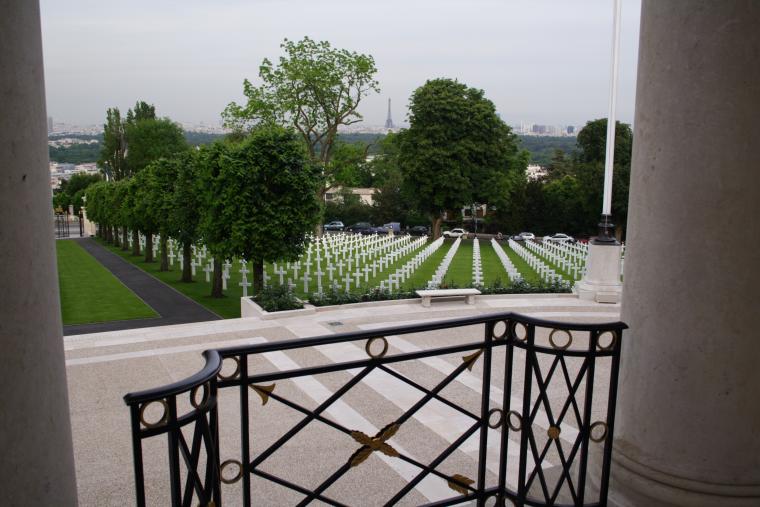 The view from the chapel shows rows of headstones, and a distant Eiffel Tower.