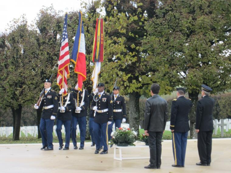 Men in uniform retire the Colors during the 2012 Veterans Day ceremony at Meuse-Argonne American Cemetery. 