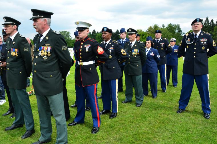 Members of military stand at attention during ceremony. 