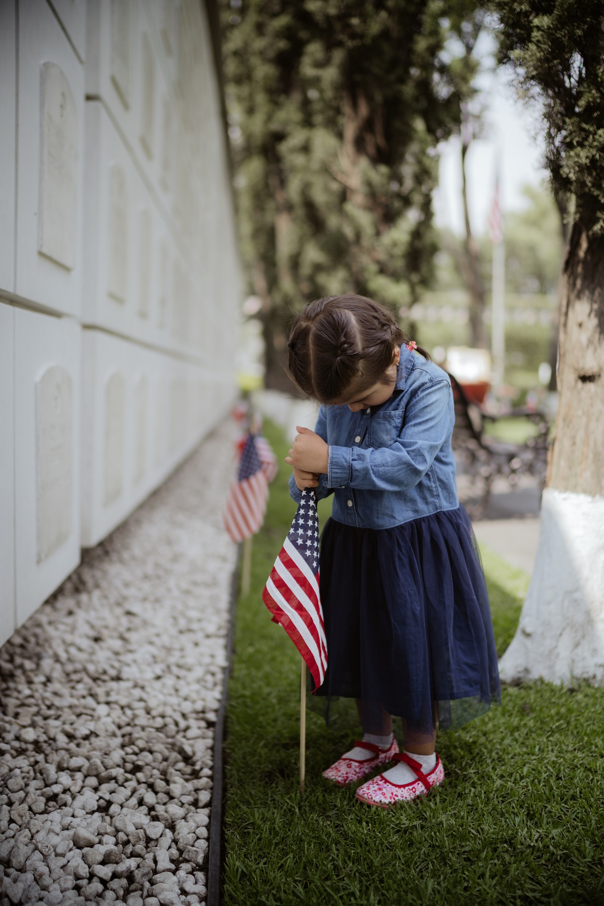 A child places a U.S. flag at Mexico City National Cemetery during ahead of Memorial Day ceremony. Photo: Mauricio Renteria FOTOGRAFÍA for ABMC.