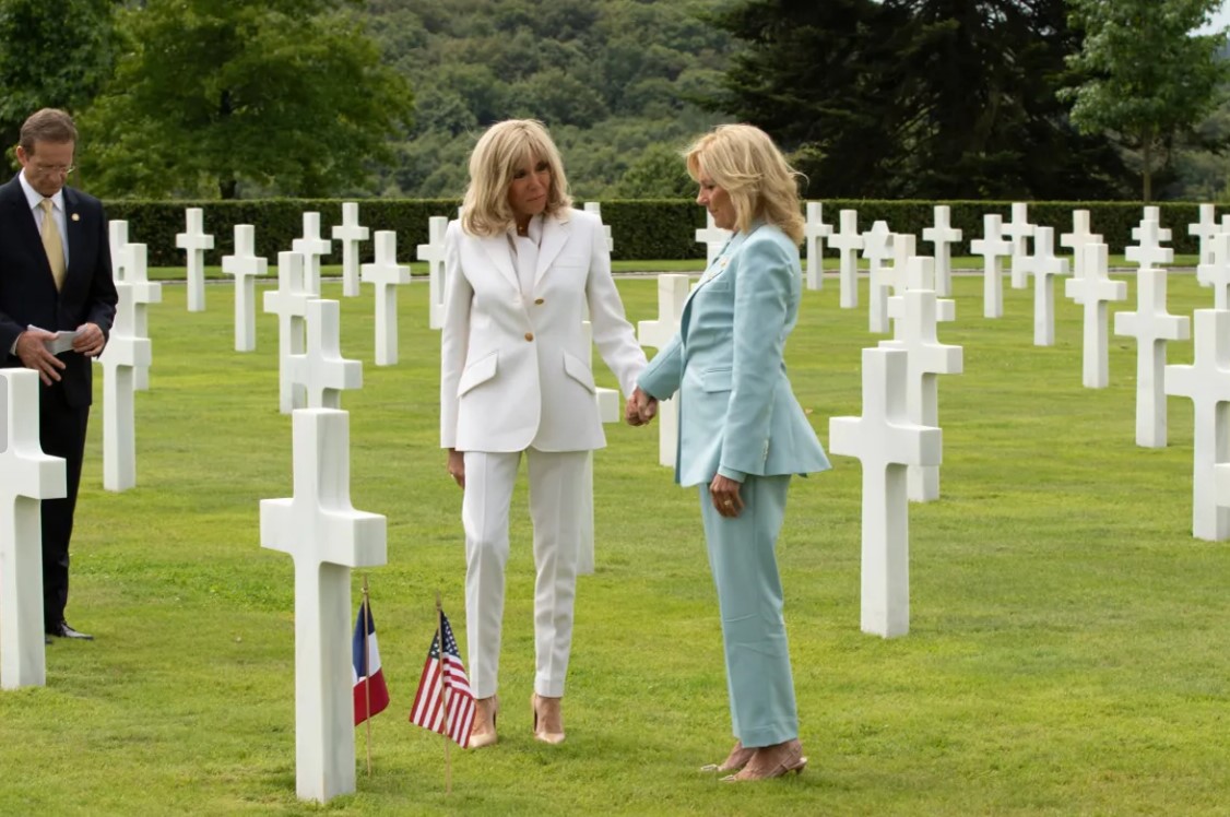 Jill Biden and Brigitte Macron holding hands at Brittany American Cemetery.  Credits: ©Jean-Marc David - SIPA