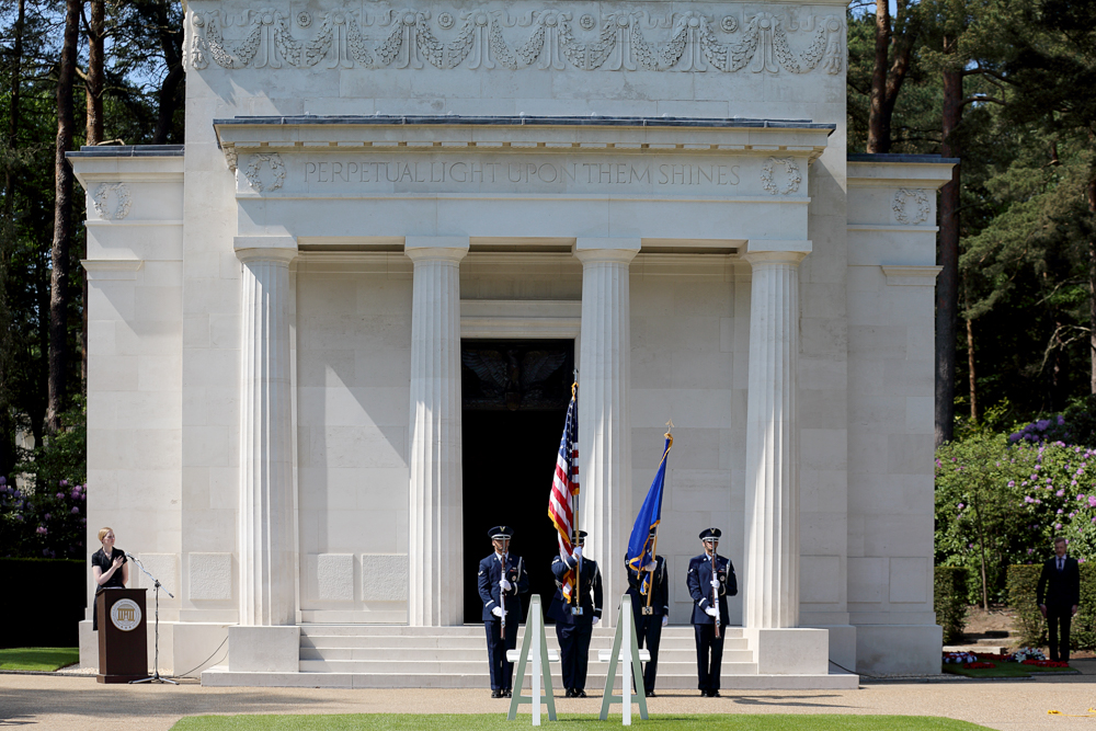 A U.S. Color Guard stands with flags and rifles outside the chapel.