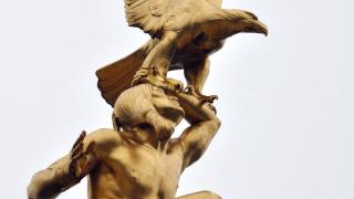 A close-up of an American Indian holding an eagle sits atop Tours American Monument.