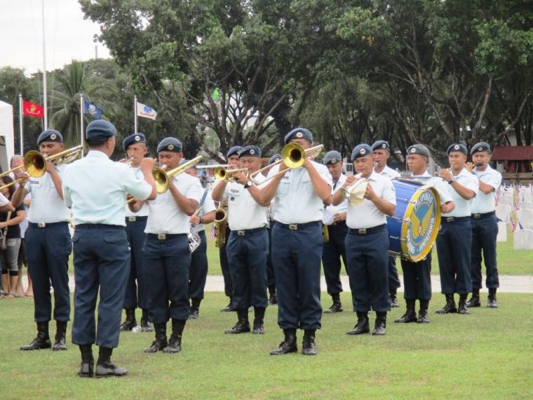 Members of the band in uniform stand in rows as they play. 