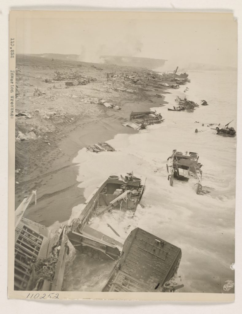 Invasion wreckage - This is a section of the beach where Marines stormed ashore on Iwo Jima, as it appeared one day after D-Day. Wreckage of landing craft along the shoreline testifies to the stiff opposition put up by the defending Japanese. Photo by U.S. Marine Corps Cpl. Eugene Jones (National Archive)