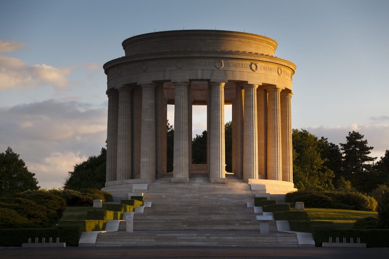 Montsec American Monument, a circular stone memorial with tall columns, set against a sunset sky in Montsec, France.