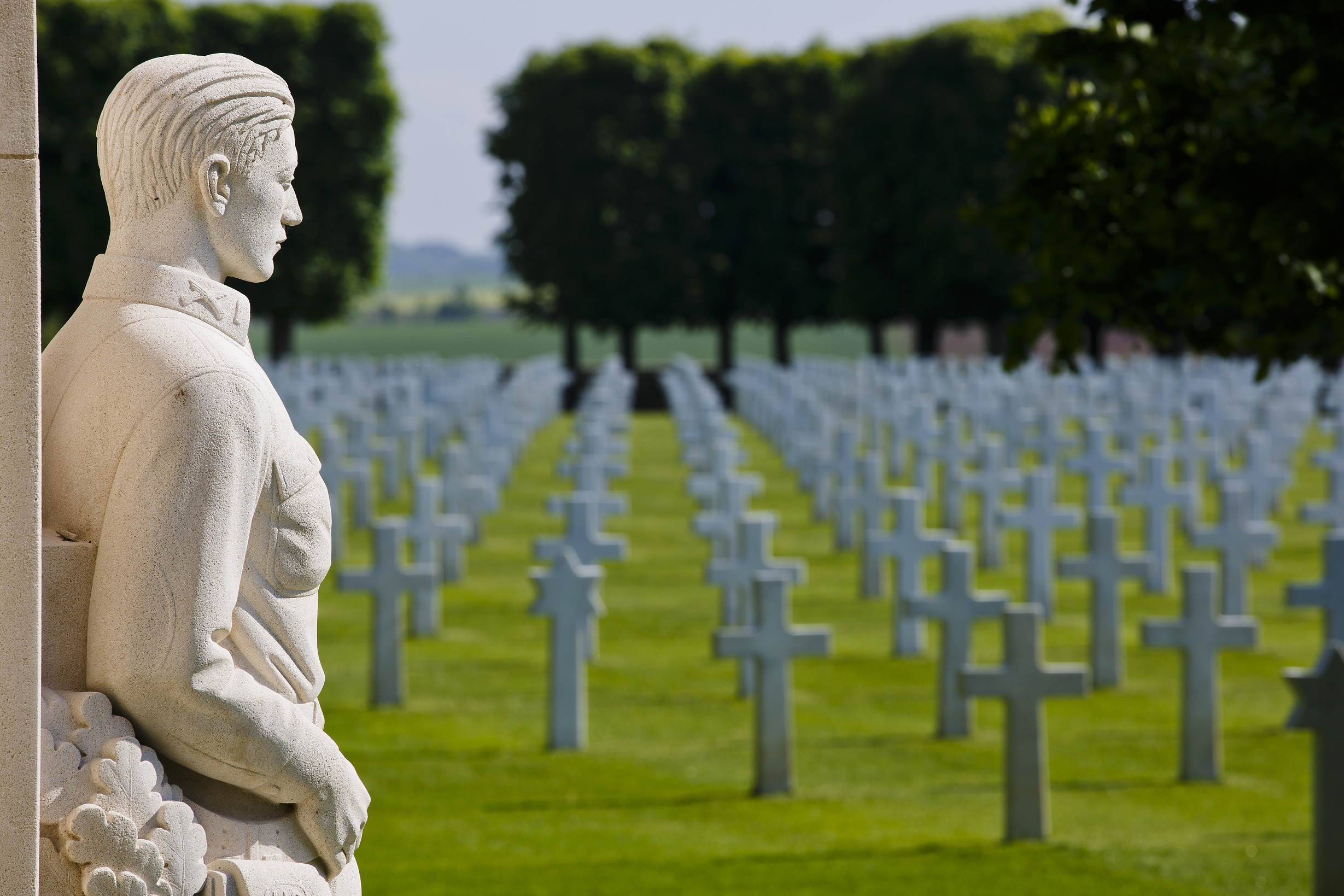 Statue of World War I soldier, with rows of grave headstones.