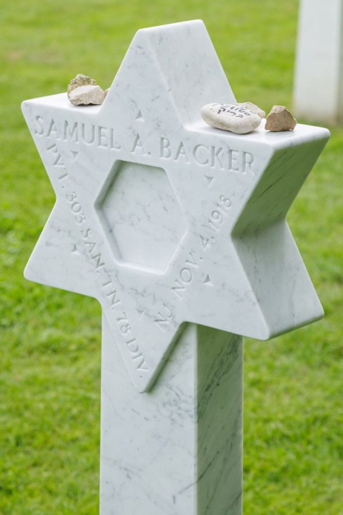 Small stones lie on the top of the headstone of Pvt. Samuel A. Backer, left by guests who witnessed the exchange of his headstone from a Latin cross to a Star of David June 2, 2026, at Meuse-Argonne American Cemetery. (ABMC photo/NGuyen-Kim)