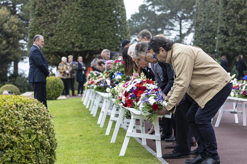Group of people placing float wreaths on a wreath stand.