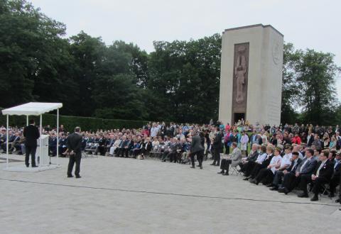 Most crowd members sit during the Memorial Day ceremony.