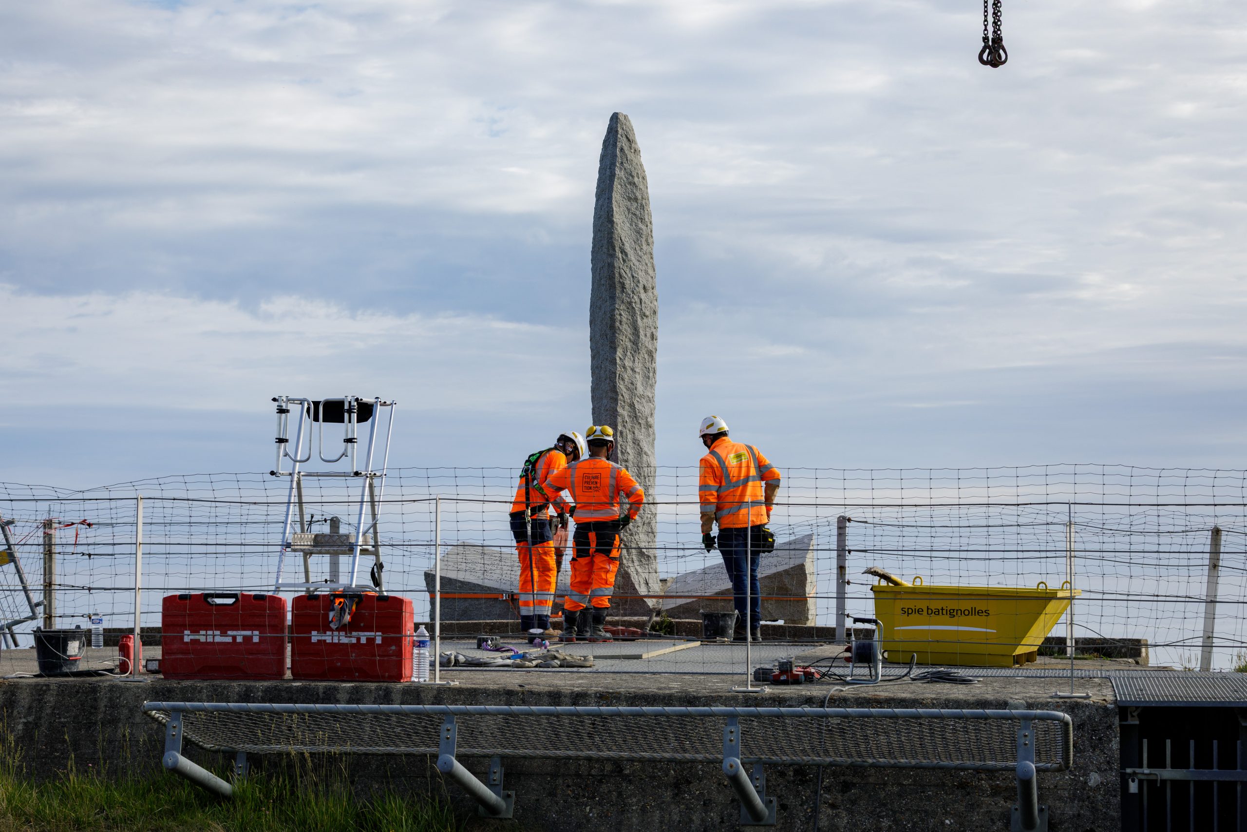 Workers in front of Pointe du Hoc Ranger Monument before its relocation. Credit: American Battle Monuments Commission.