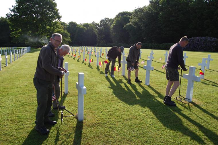 Staff at Ardennes American Cemetery in Belgium place an American flag and a Belgian flag in front of every headstone at the cemetery in preparation for Memorial Day 2014.