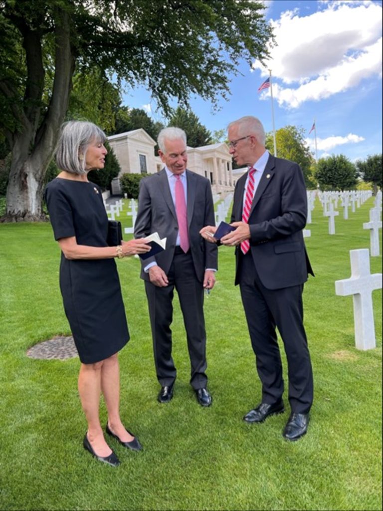 ABMC Executive Director for Operations Thomas Spoehr presents U.S. Ambassador to France Charles Kushner and his wife Seryl an ABMC passport to document their visits to ABMC sites. Credit: American Battle Monuments Commission.