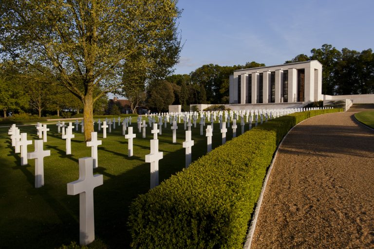 Picture of Cambridge American Cemetery with some headstones in the front and the chapel in the back. Credit: American Battle Monuments Commission/ Warrick Page.