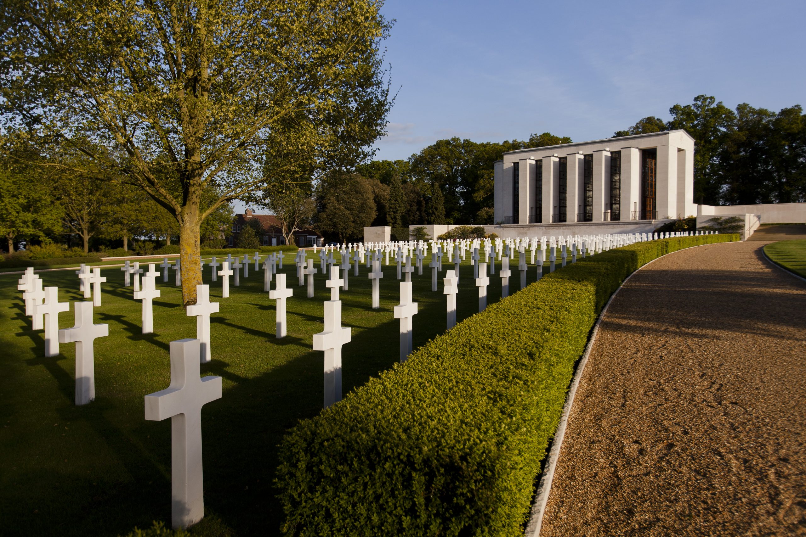 Pictures of headstones of Cambridge American Cemetery with its Memorial in the background. Credit: American Battle Monuments Commission/ Warrick Page.
